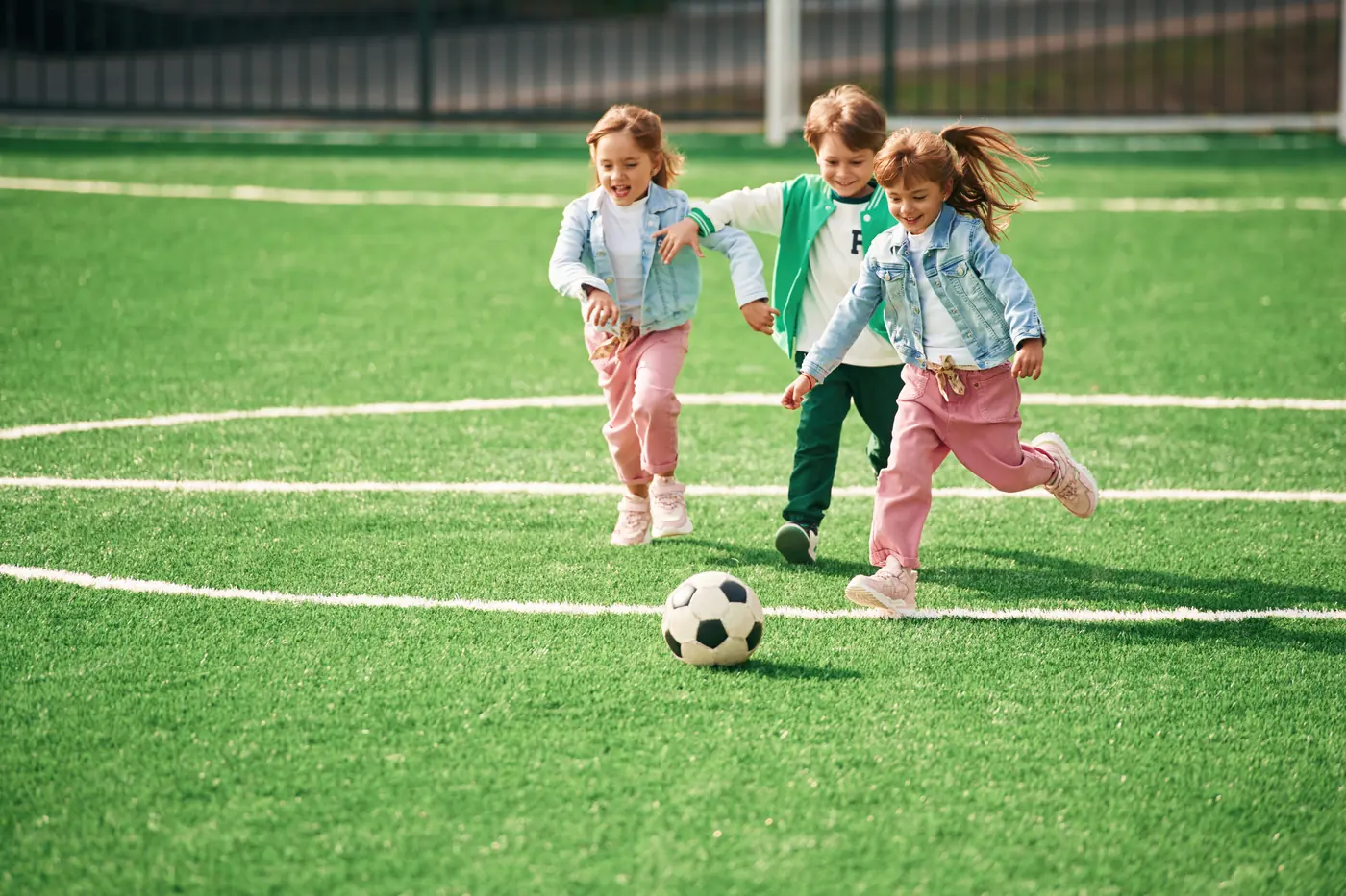 Niños jugando fútbol sobre pasto